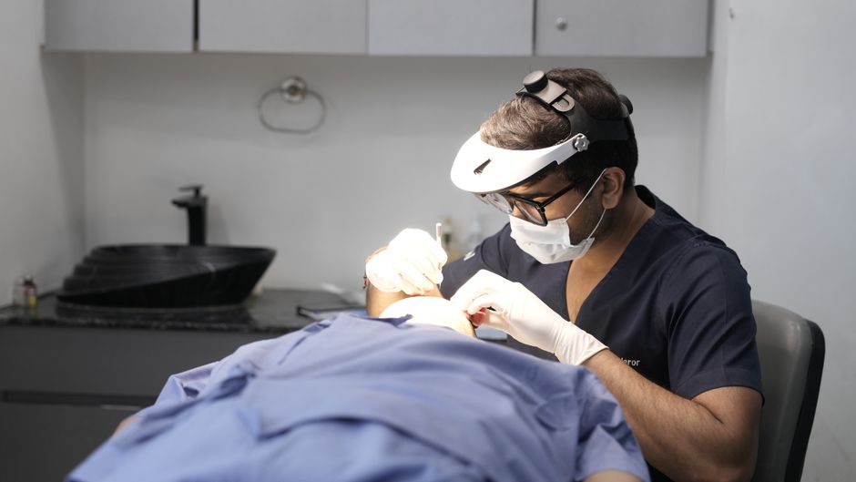 A dermatologist examining a patient's skin in a clinic